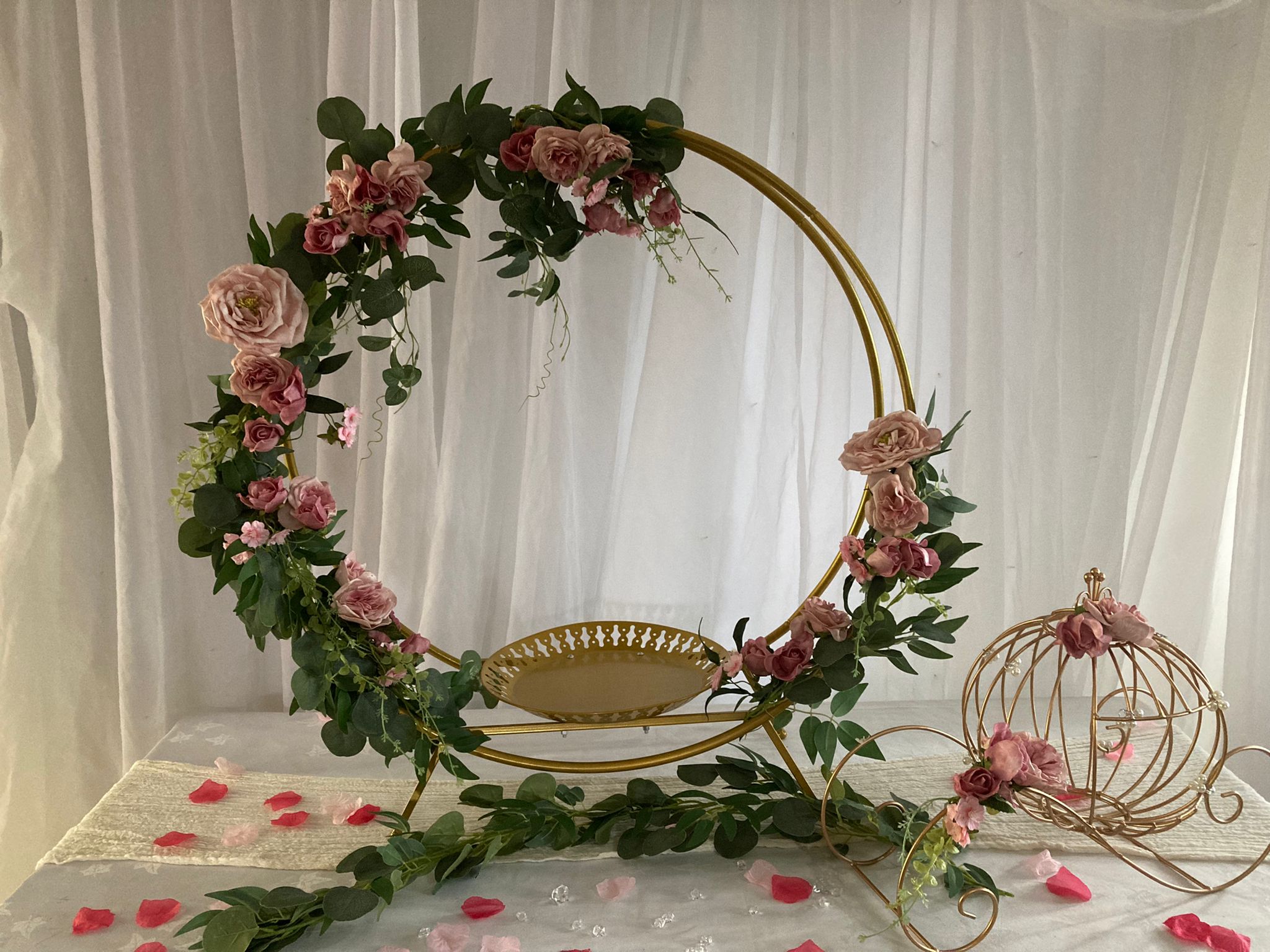 Gold hoop cake stand with pink roses around the edge and Cinderella coach at the side