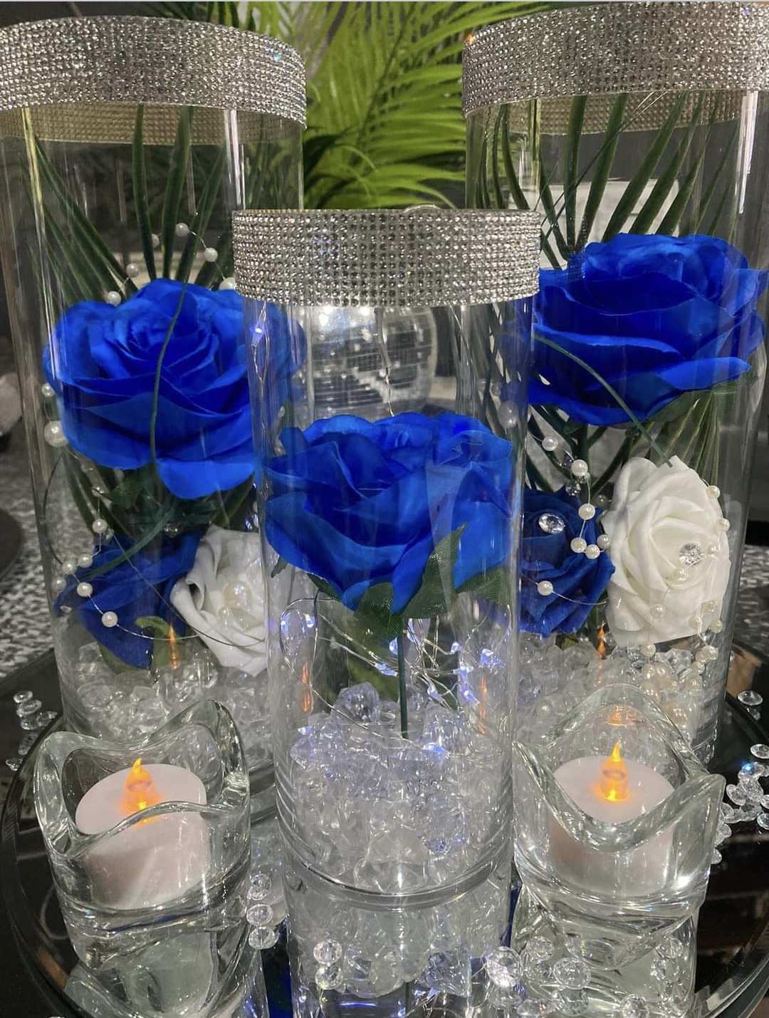 3 glass vases with diamanté rims and filled with blue and white roses