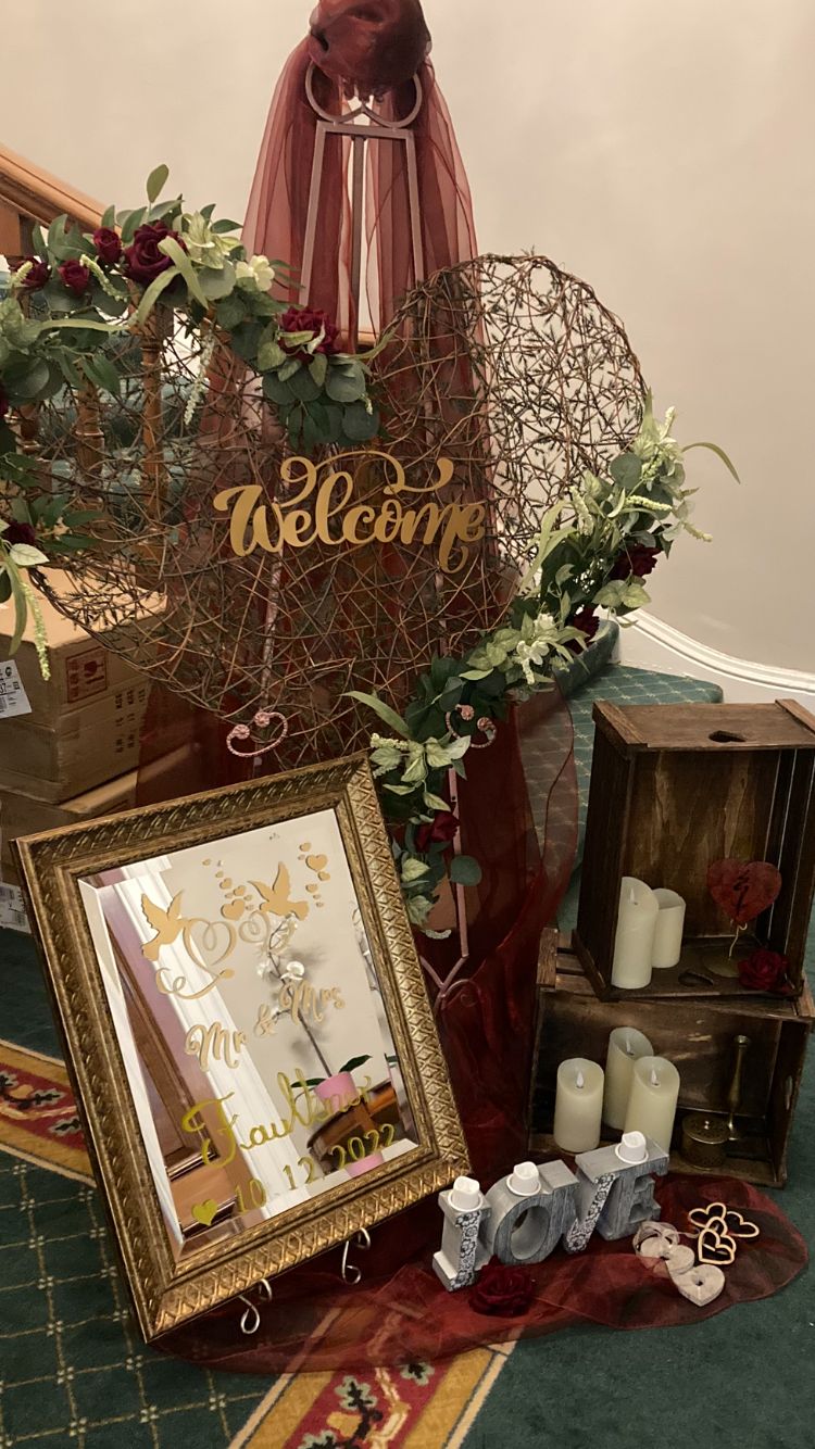 Small gold mirror welcome to our wedding, with large wicker heart, decorated with red swag and ivy