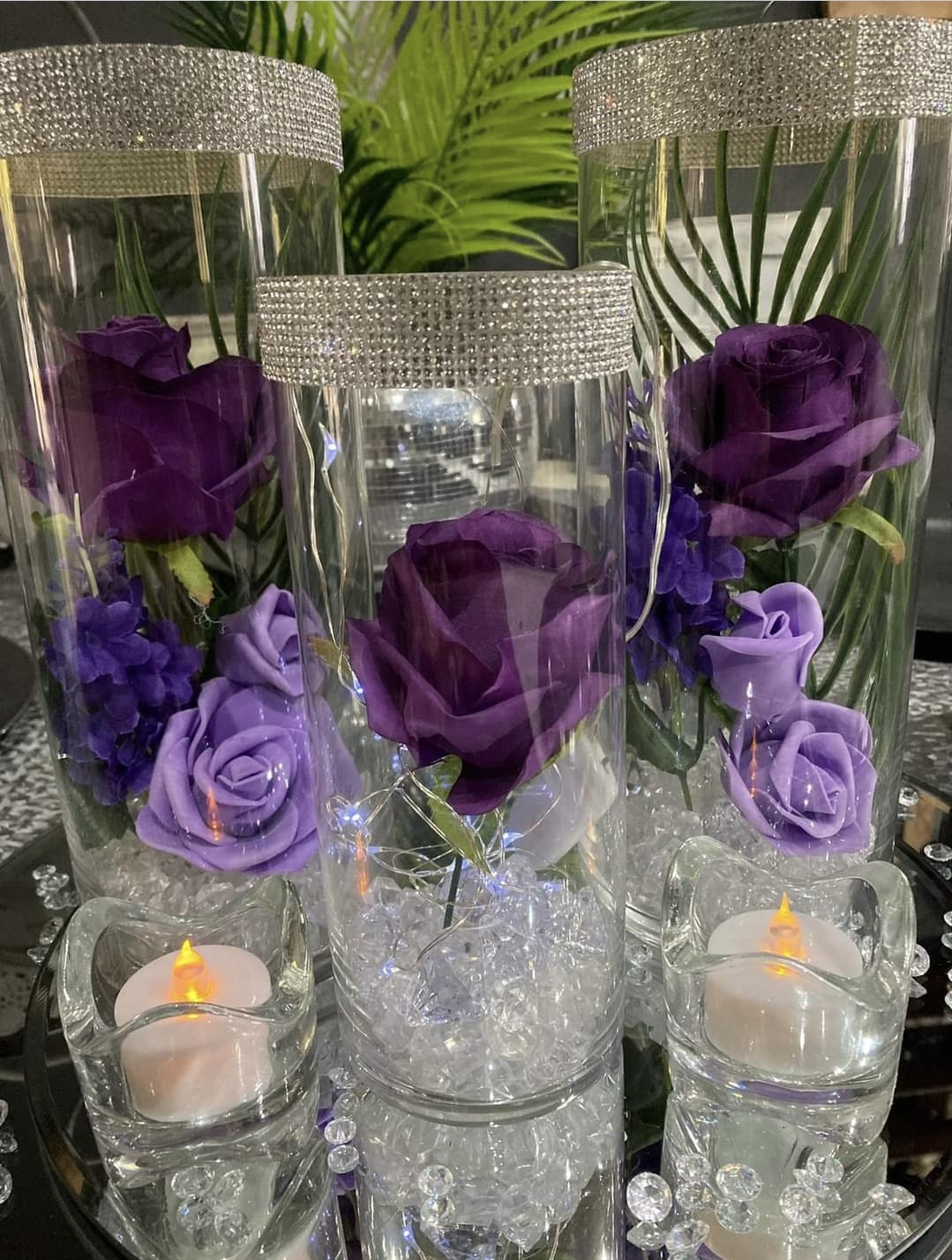 3 glass vases with diamanté rims and filled with purple flowers