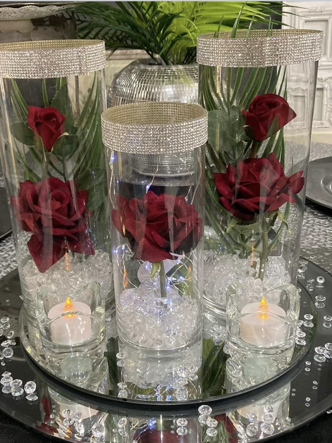 3 glass vases with diamanté rims and filled with red roses