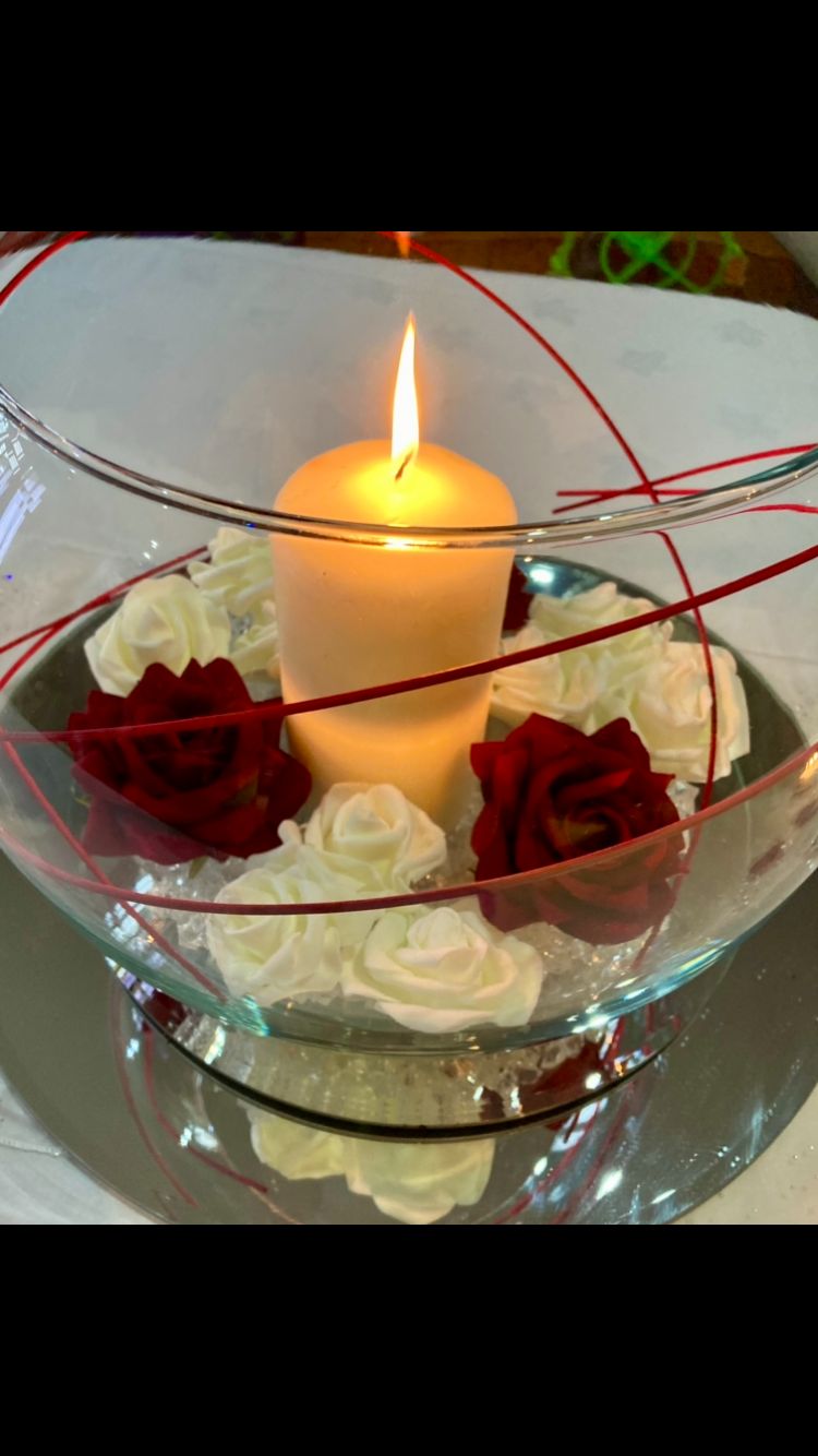 Fish bowl centrepiece with candle and red and white roses