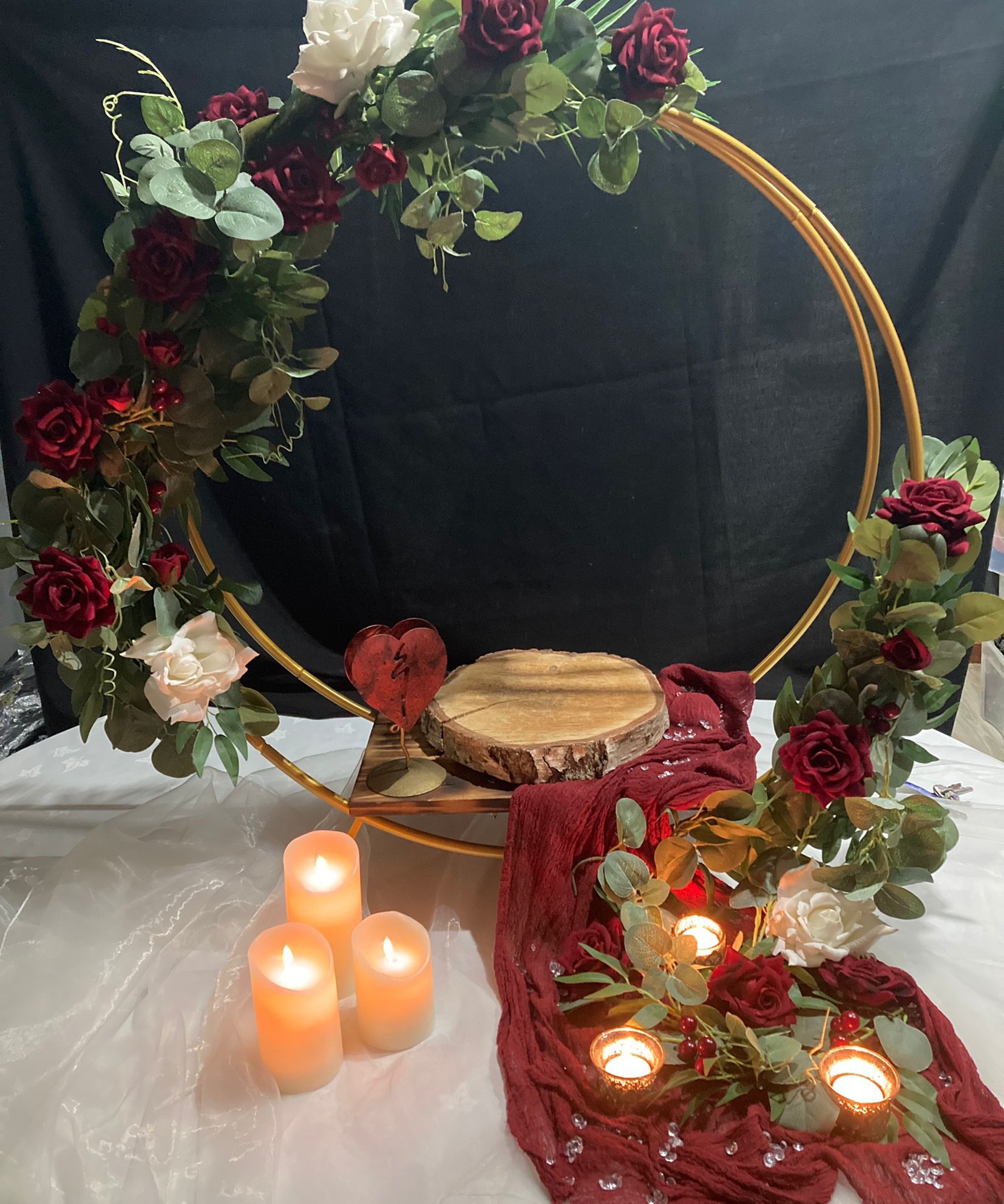 Gold hoop cake stand with red swag and candles