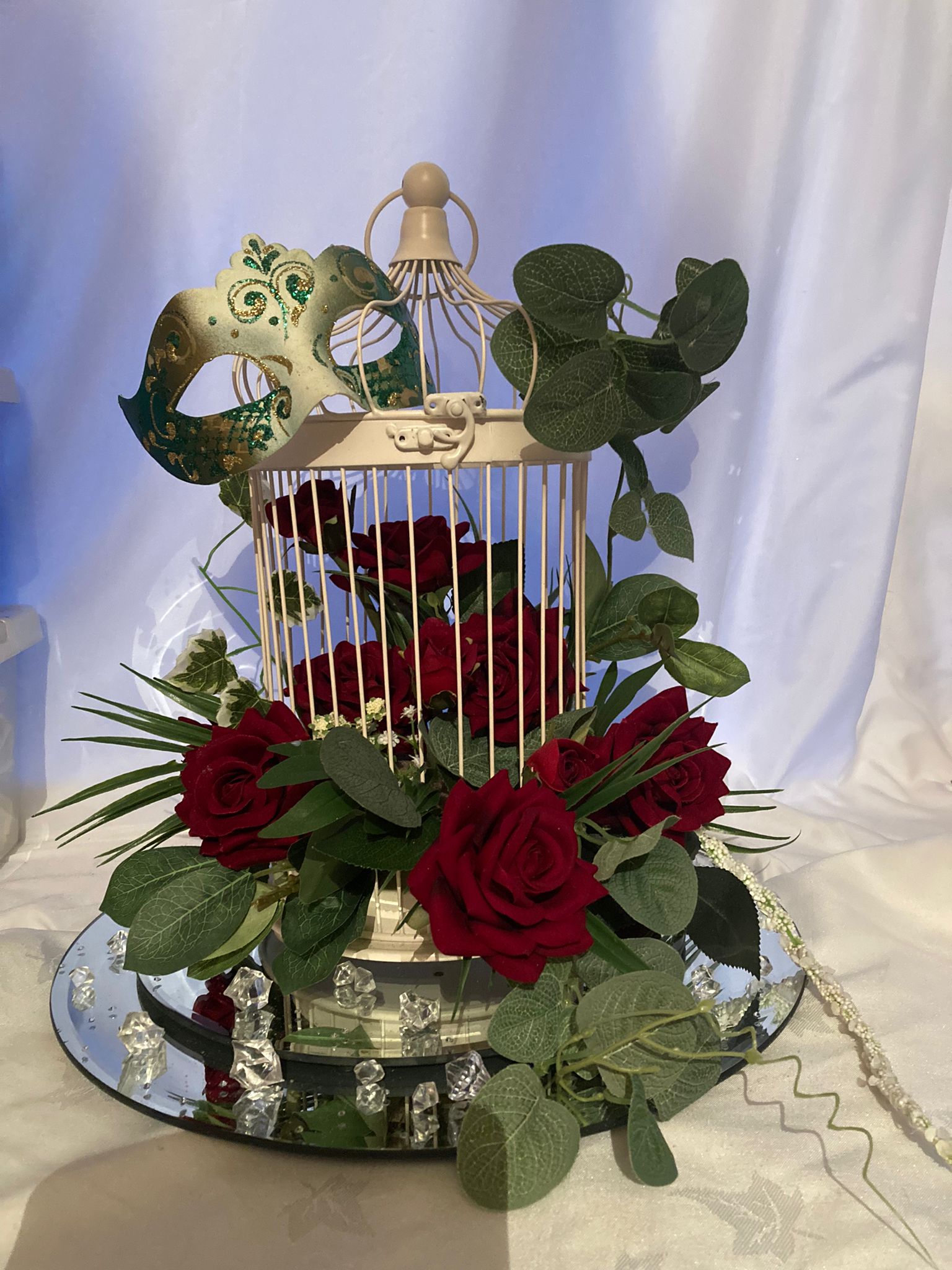 Bird cage centrepiece with mirror plate and red roses