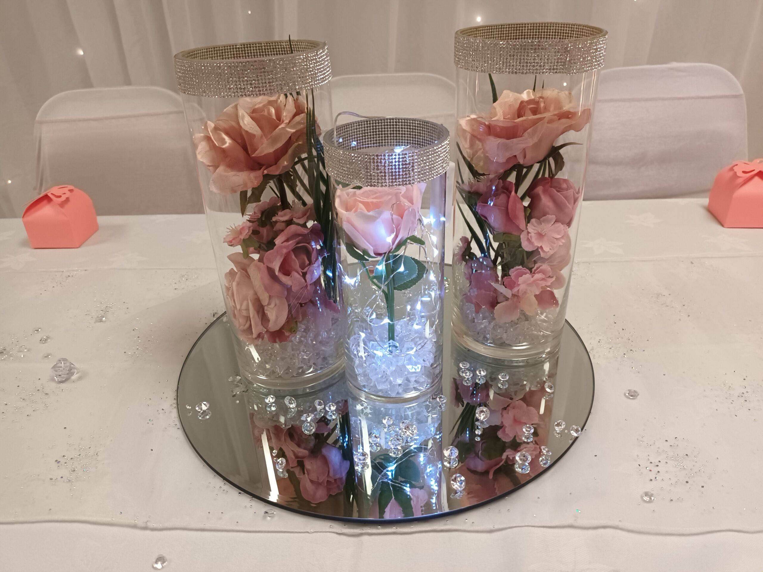 3 glass vases with diamanté rims and filled with pink roses
