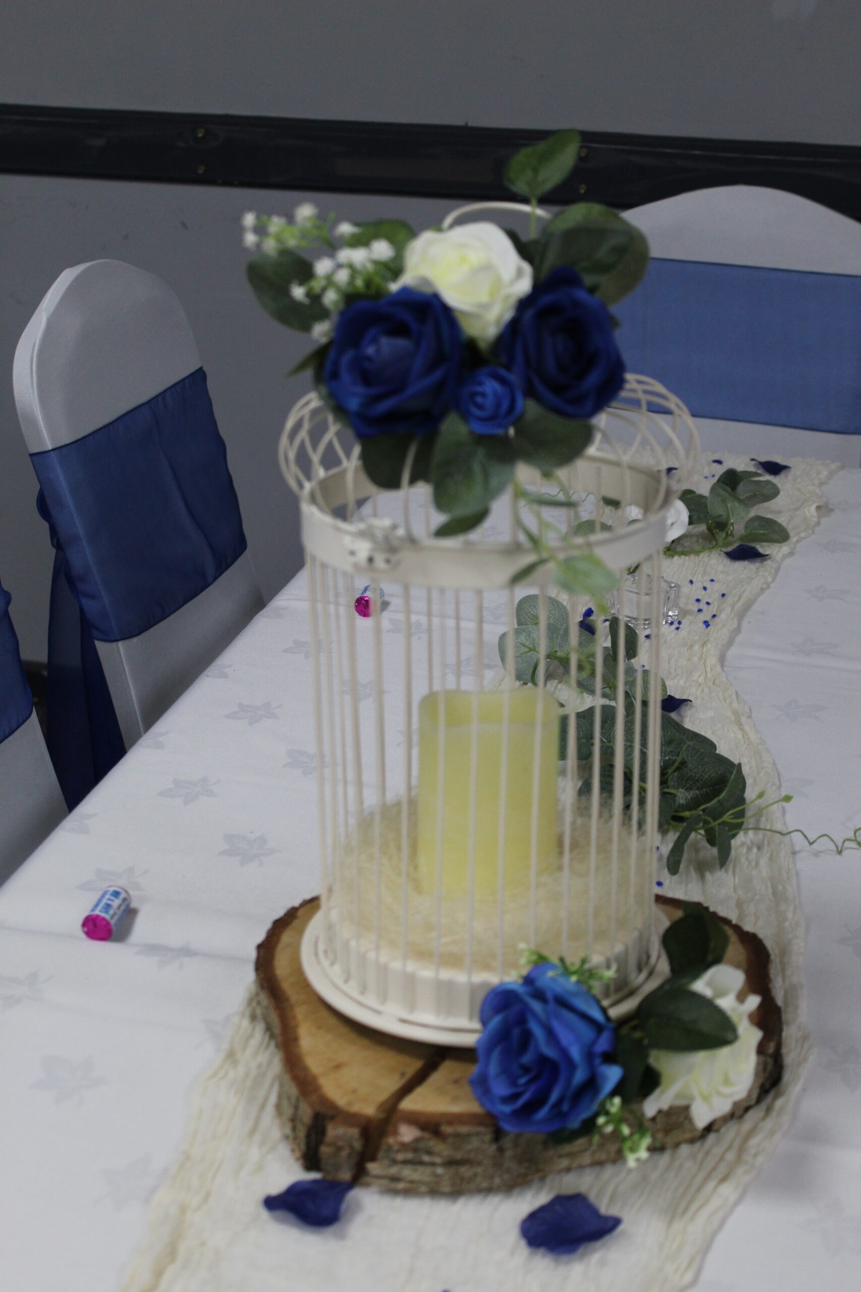Bird cage centrepiece with candle and blue roses