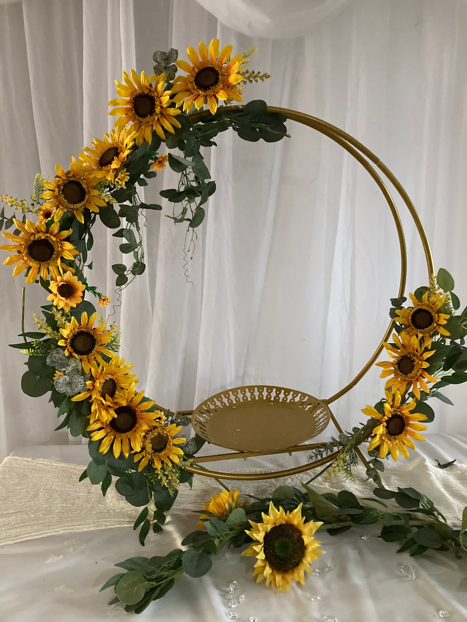 Gold hoop cake stand with sunflowers around the edge
