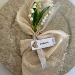 Gold charger plate with white napkin and flower for winter wedding