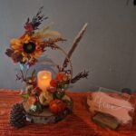 Centrepiece in orange and red colours, wooden rings on a log slice