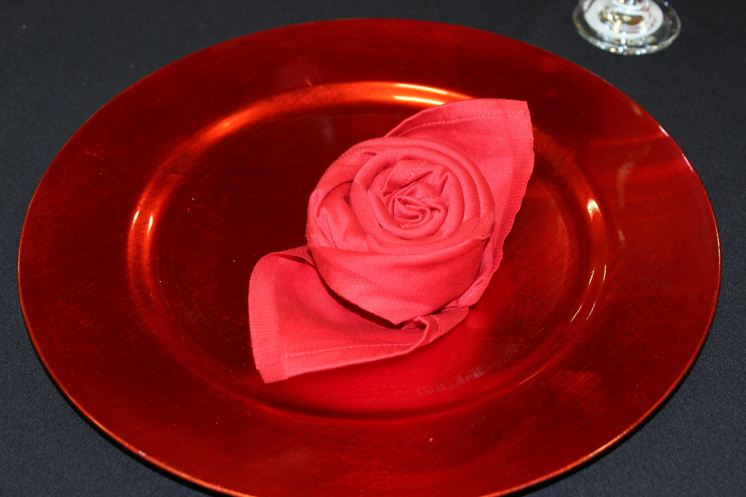 Red charger plate with red rose napkin