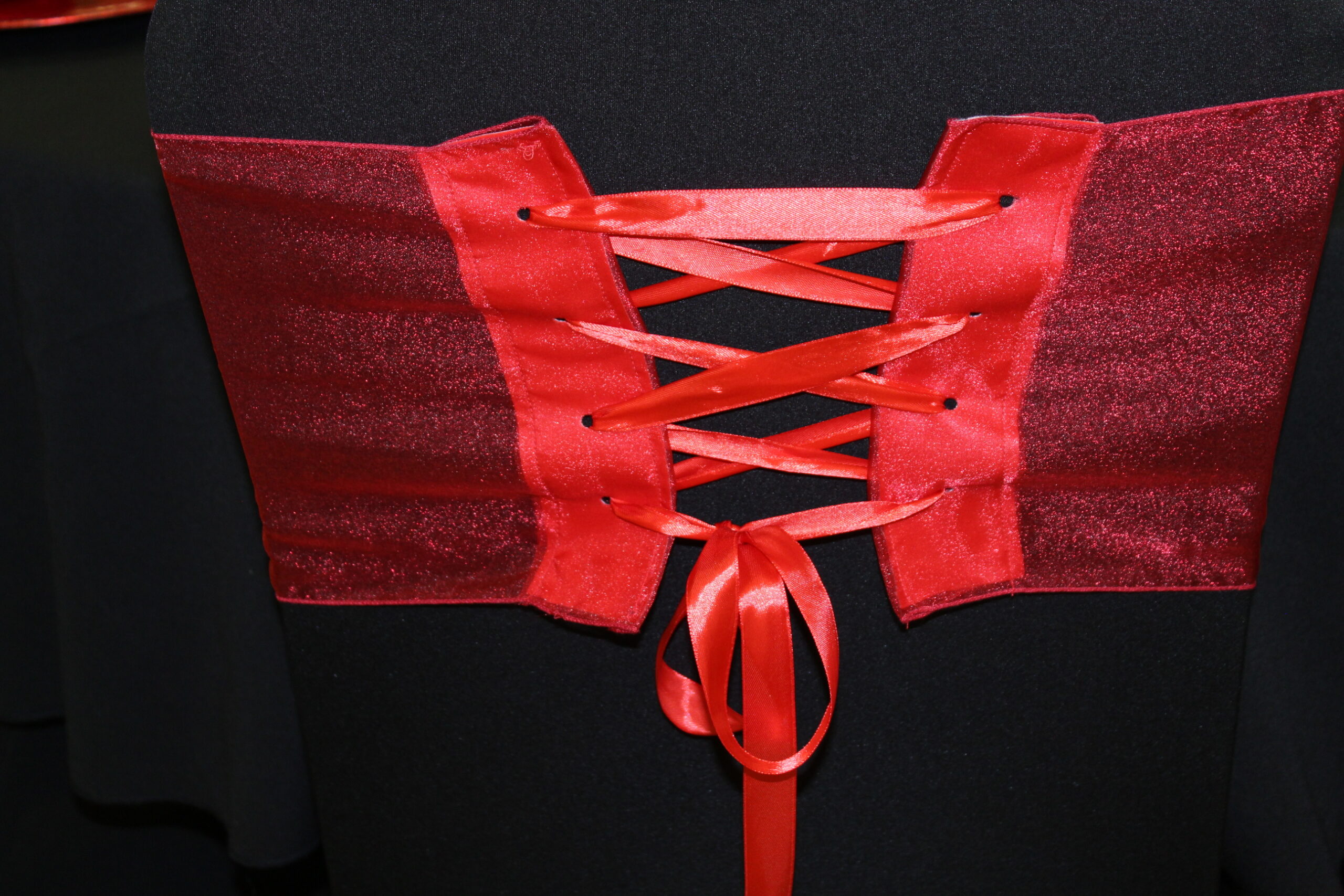 Red corset style sash on black chair cover