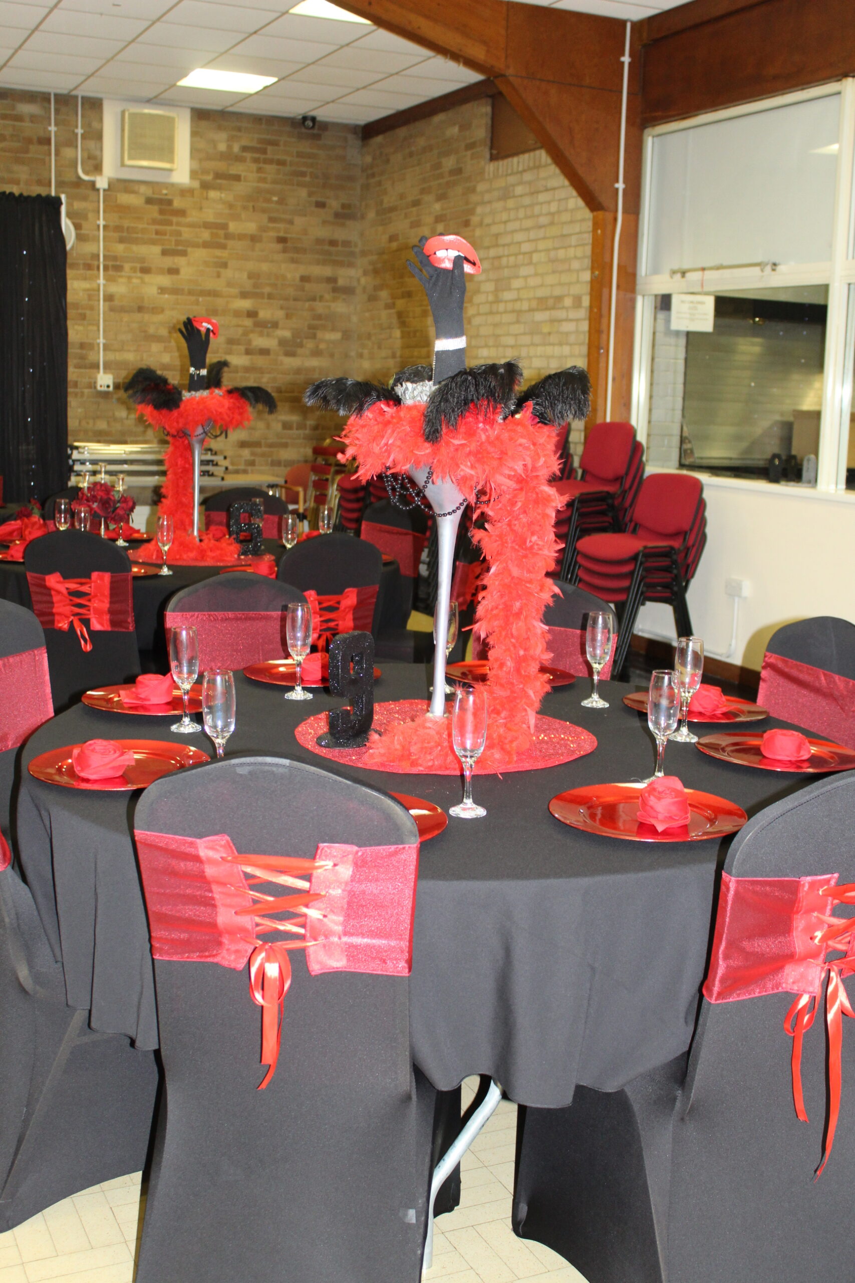 Rocky horror party table set up, black chair covers with red corset sashes,