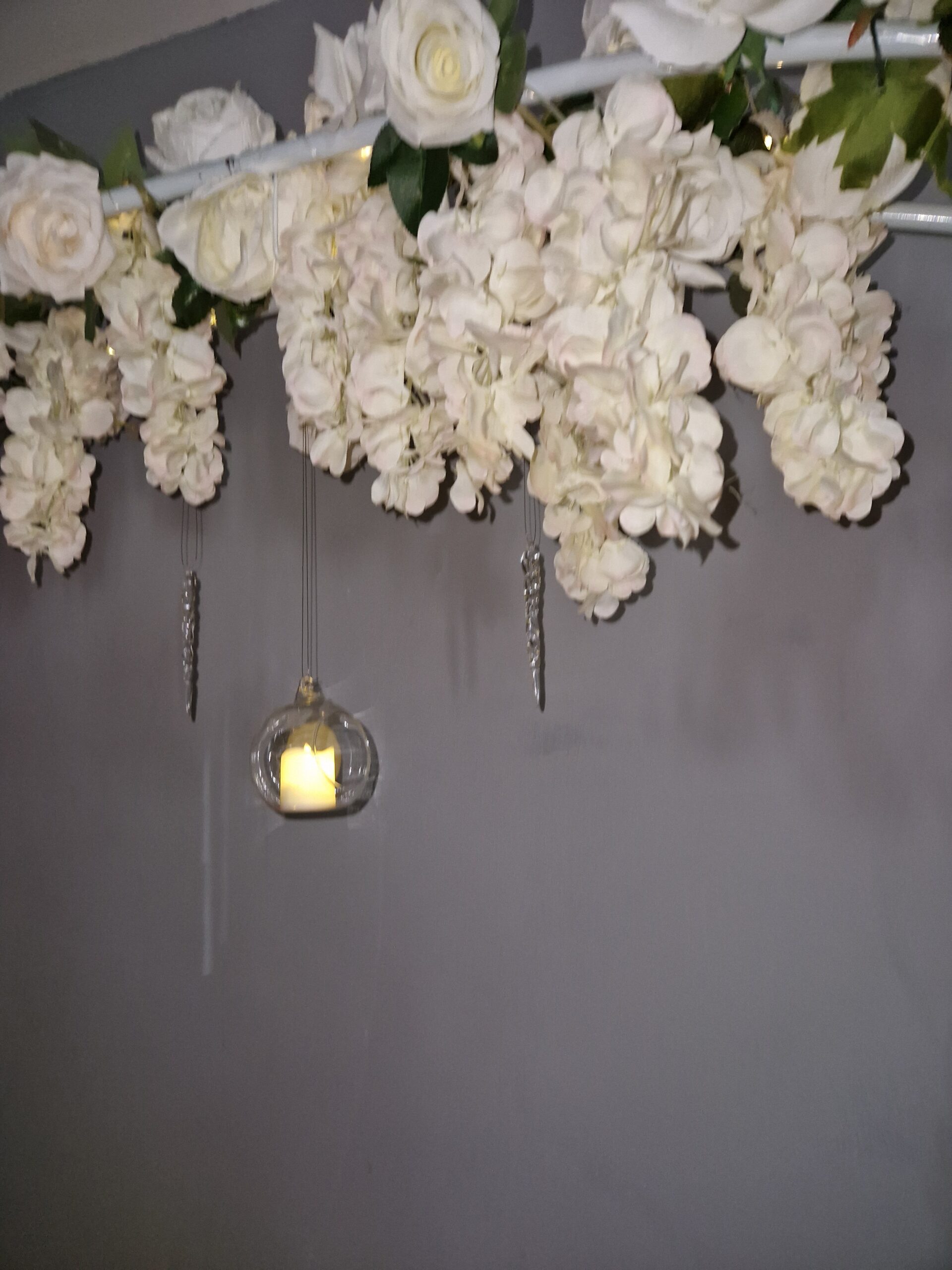 White flower garlands hanging from the winter wedding arch
